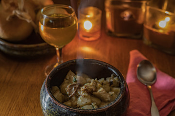Steamy hot gnocchi with chicken and mushrooms with wine, candles and onion