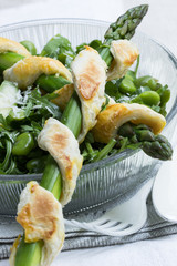 Grüner Spargel in  Blätterteig auf Frühlingssalat mit Parmesan in einer Glasschale mit Besteck