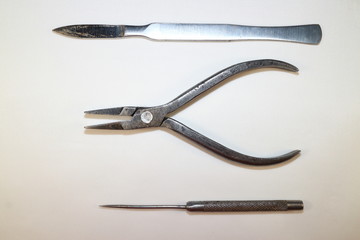 tool for work, metal pliers, scalpel and awl against white background