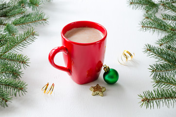 Red mug of cocoa with milk and Christmas decoration