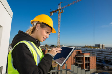 woman construction worker with hardhat using tablet pc