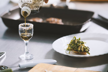 Chef serves food on the plate in restaurant