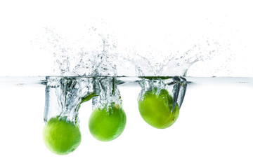 Fototapeta na wymiar Fresh lime dropped into the water with water splash on a white background