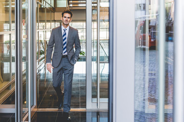 businessman comes out of an office building