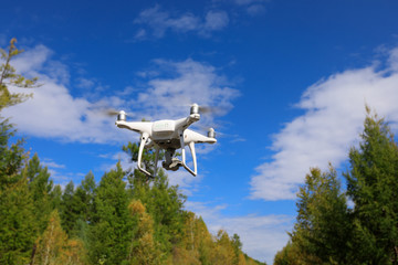 one drone flying in the air over autumn forest