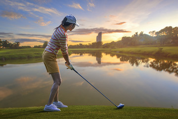 woman golf player prepare standing address on the tee off in golf course, ready to hit the ball...