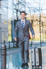 businessman walks with a trolley bag in the city