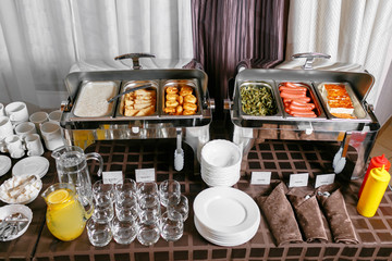 Many buffet heated trays ready for service. Breakfast in hotel catering buffet, metal containers with warm meals