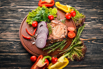 Grilled Steak, with Vegetables. Pork, veal, meat. On a wooden background. Top view. Free space for text.