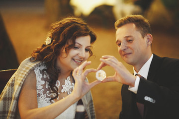 Brides hold a coin with a keyhole sitting outside