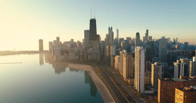 Aerial shot of Chicago Downtown skyline at sunrise. Buildings by the lake with road and cars