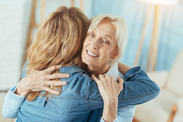 Feeling warmth. Happy emotional aged woman feeling good while being at home and meeting her clever...