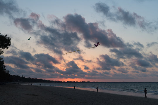 Drachenfliegen am Strand beim Sonnenuntergang