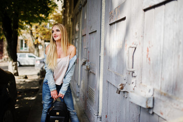 Obraz na płótnie Canvas Blonde girl wear on jeans jacket posed at street.
