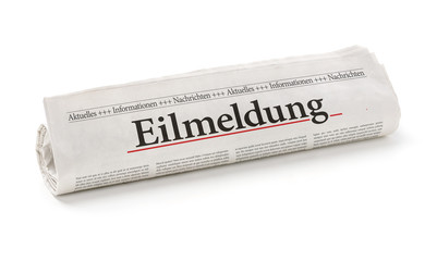 Zeitungsrolle mit der Überschrift Eilmeldung