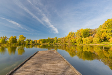 Beautiful autumn lake landscape. Colorful trees and blue sky