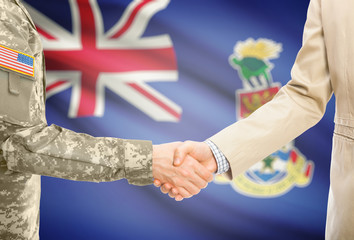 USA military man in uniform and civil man in suit shaking hands with adequate national flag on background - Cayman Islands