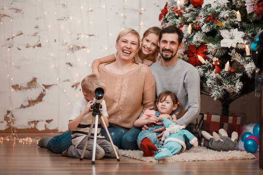 New Year's picture of family sitting at decorated Christmas tree
