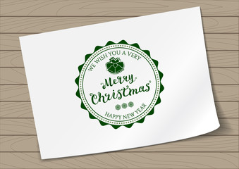 Round in Frame Badge Merry Christmas and Happy New Year with Hand Drawn Lettering and Bells Icon on A4 Sheet Paper on Wooden Background. Green Logo Emblem Vector Illustration.
