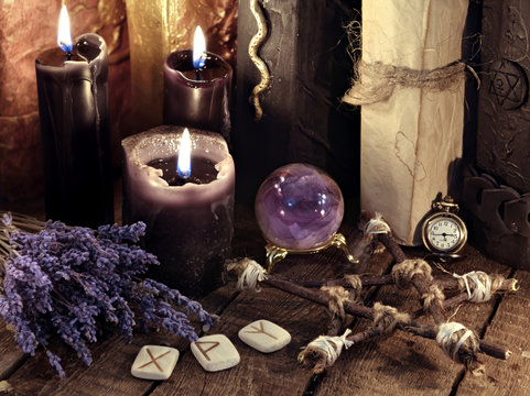Black candles, pentagram, runes and lavender flowers with crystal ball. Occult, esoteric, divination and wicca concept. Mystic and vintage background
