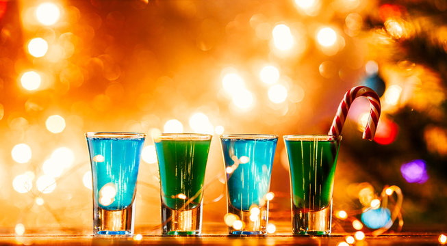 Christmas image of four wine glasses with green cocktail, caramel sticks