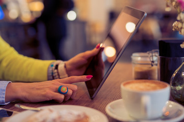 Fototapeta na wymiar Woman using digital tablet in cafe