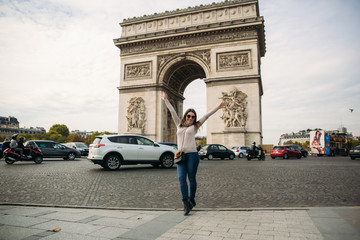 Girl is standing neat the arch of triumphal.