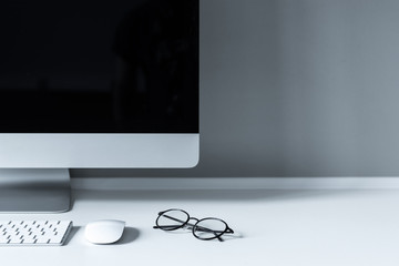 glasses and computer mouse with keyboard on working table