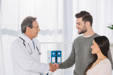 Obraz premium doctor and smiling patient shaking hands