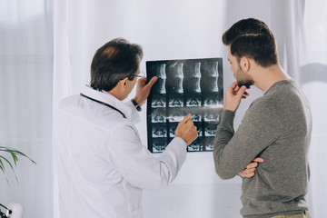 Obraz premium doctor pointing on male patient x-ray photo
