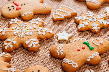 Obraz na płótnie Canvas Christmas gingerbread cookies homemade and New Year decor on table with burlap tablecloth. Merry Christmas postcard.