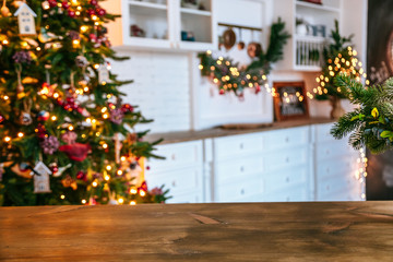 Fototapeta na wymiar Christmas holiday background with empty rustic table and the bokeh of the living room with the Christmas tree on the second plan