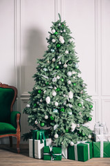 Christmas tree with gifts and sofa in Christmas living room. Beautiful New Year decorated classic home interior. Winter background