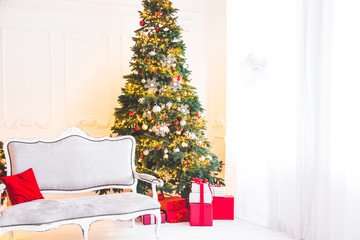 Christmas living room with a Christmas tree, sofa, gifts and a large window. Beautiful New Year decorated classic home interior