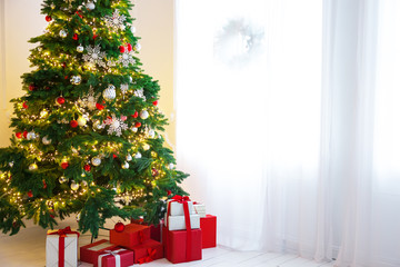 Christmas living room with a Christmas tree, gifts and a large window. Beautiful New Year decorated classic home interior
