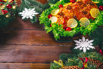 Thanksgiving table served with  baked meats, decorated with bright Christmas decor and candles. Christmas dinner with roasted pork meat. The concept of a family holiday, delicious food