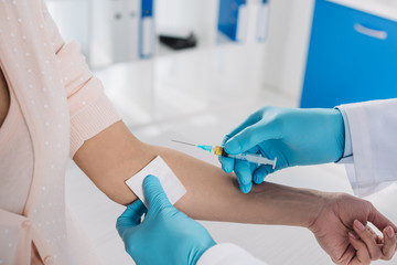 cropped image of doctor taking patient blood for test