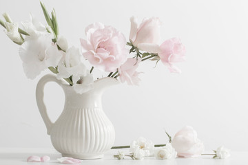 pink and white flowers in vase on white background
