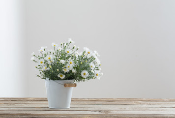 white flowers on bucket on wooden table