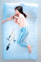 Fototapeta na wymiar Flower fragrance. Relaxed female lying on her bed and being in semi position while keeping legs bent in knees