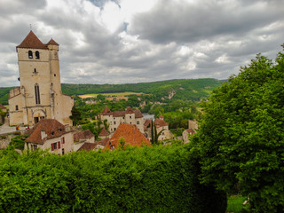 Fototapeta na wymiar Saint Cirq Lapopie fortified medieval church in France on a cloudy day.