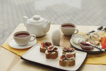 tasty healthy breakfast with tea set on wooden table