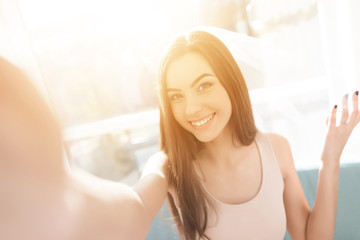 Naklejka premium Pre-wedding care. The girl is preparing for a hen-party. She sits on the couch in a bright room.