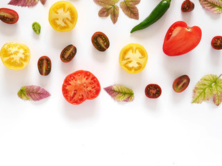 Food collage of fresh vegetables, top view. Tomatoes in a cut, pepper, autumn leaves isolated on white background. Abstract composition of vegetables, concept of healthy eating.