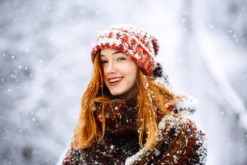 Young woman winter portrait. Close-up portrait of happy girl. Expressing positivity, true brightful emotions. Christmas Girl. Beautiful model girl with shiny red long hair