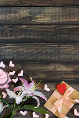 Marshmallow hearts, love letter and flowers on an old wooden background