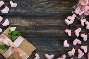 Marshmallow hearts, love letter and flowers on an old wooden background