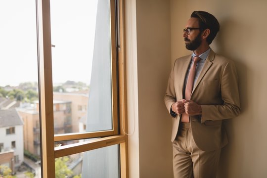 Man in full suit looking through window