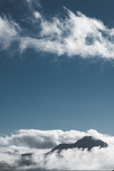 sommet de montage dans les nuages sur fond de ciel bleu