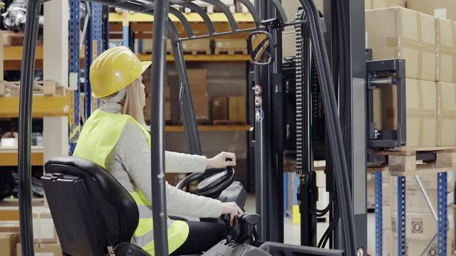 Woman warehouse worker with forklift.